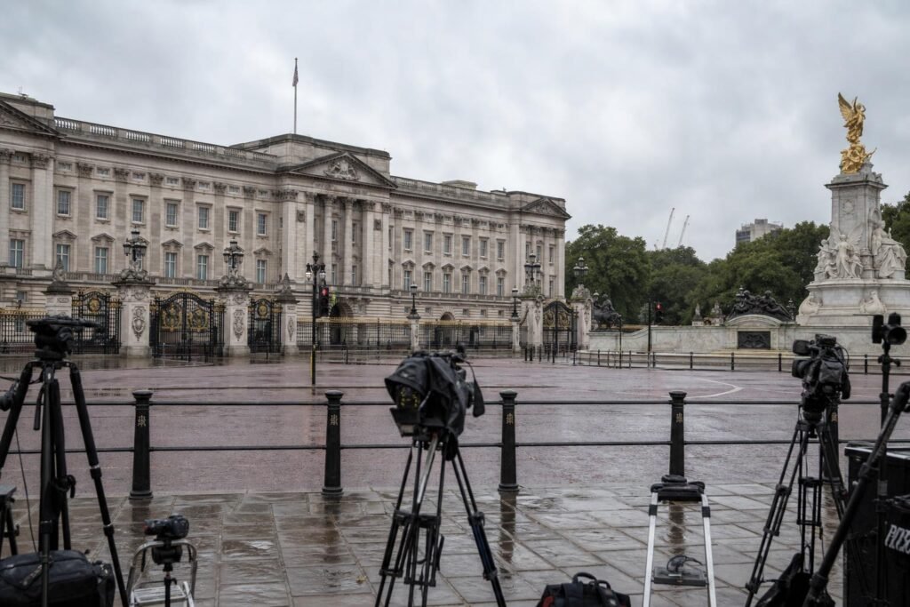 Londoni palota előtt várakozó újságírók a királyi visszatérés hírének illusztrációjaként
